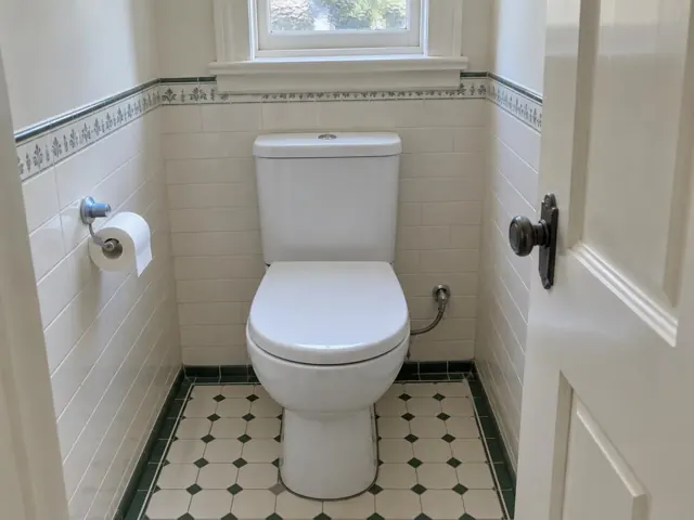 Clean white toilet in a tiled bathroom under a window in Bellevue Hill